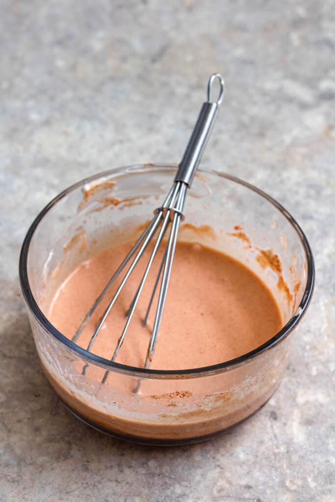 bowl of sauce with a whisk in it