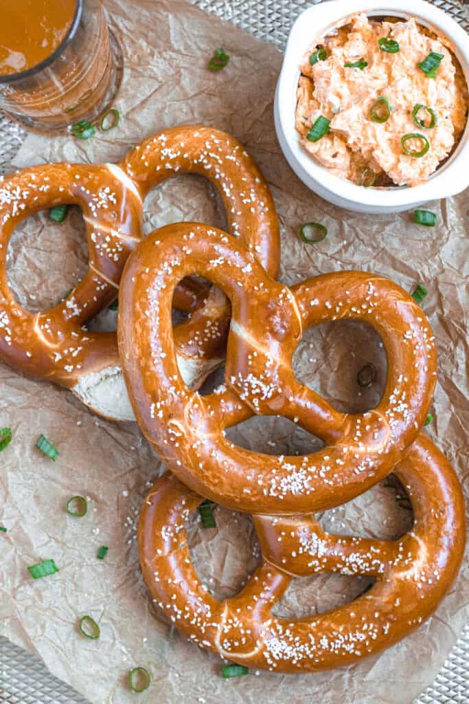 soft pretzels on a crumpled sheet of parchment paper with beer cheese spread 