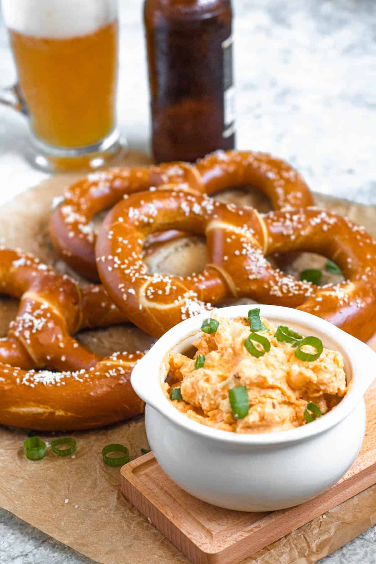 German Obatzda in a serving platter sitting in front of German soft pretzels.