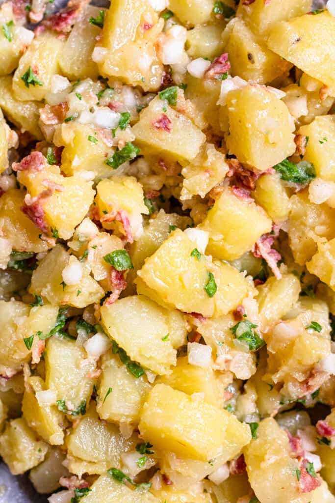 close up of German potato salad with bacon bits and onions