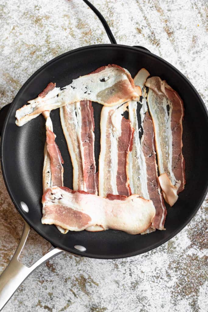 raw bacon in a frying pan 