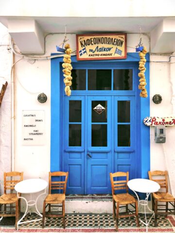 A blue door outside of a greek restaurant.