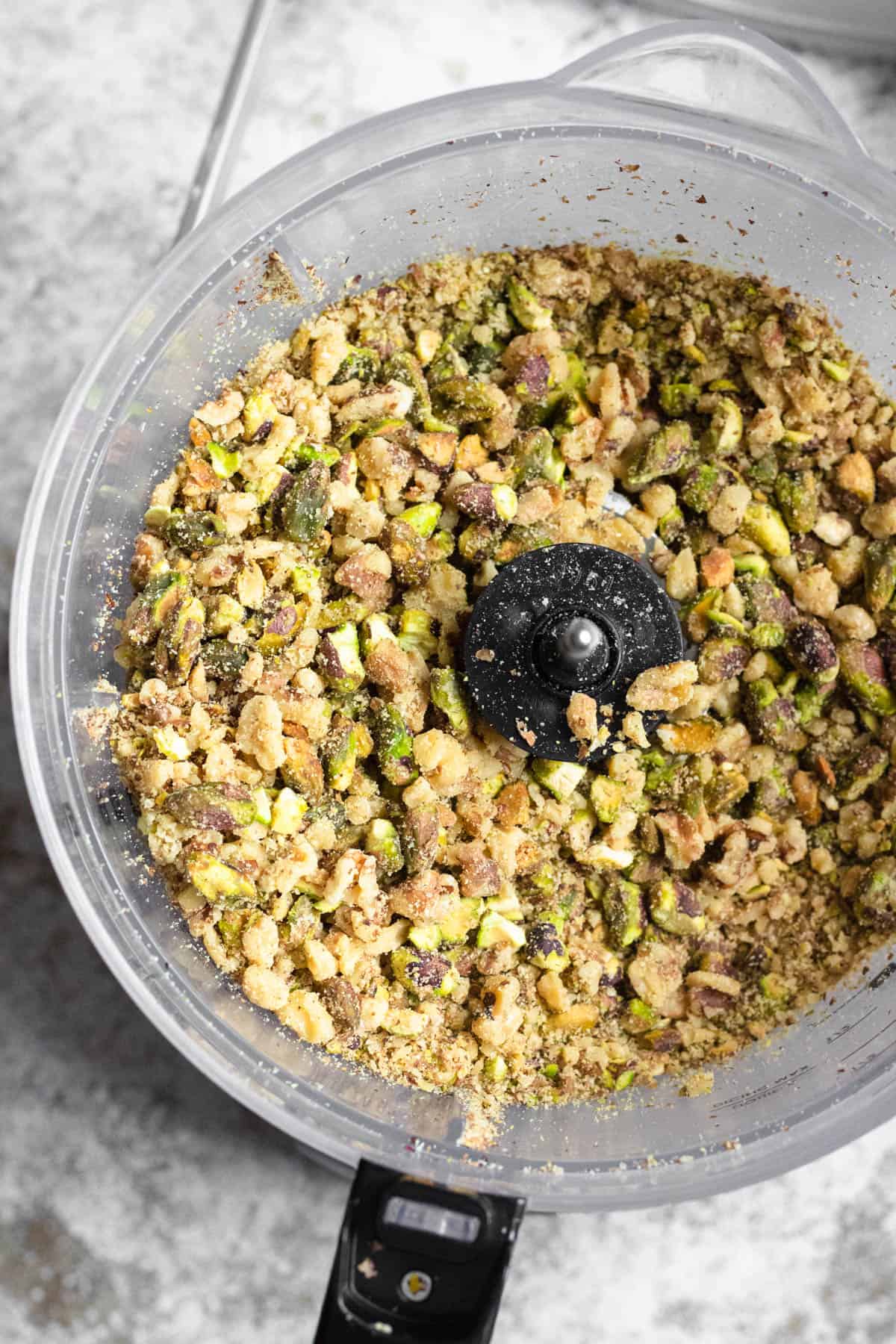 Ground up pistachio nuts inside a food processor to prepare Pistachio Baklava.