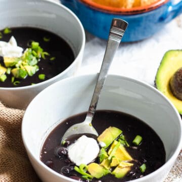 Black bean soup topped with sour cream and cubed avocado.