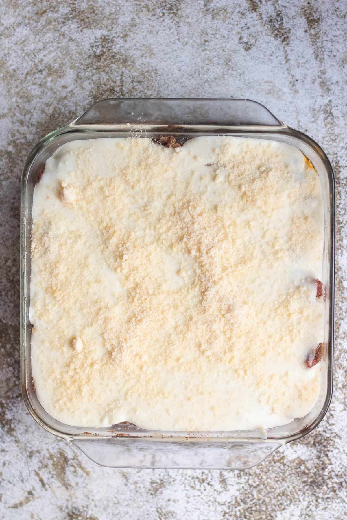 glass dish with béchamel and parmesan cheese on top