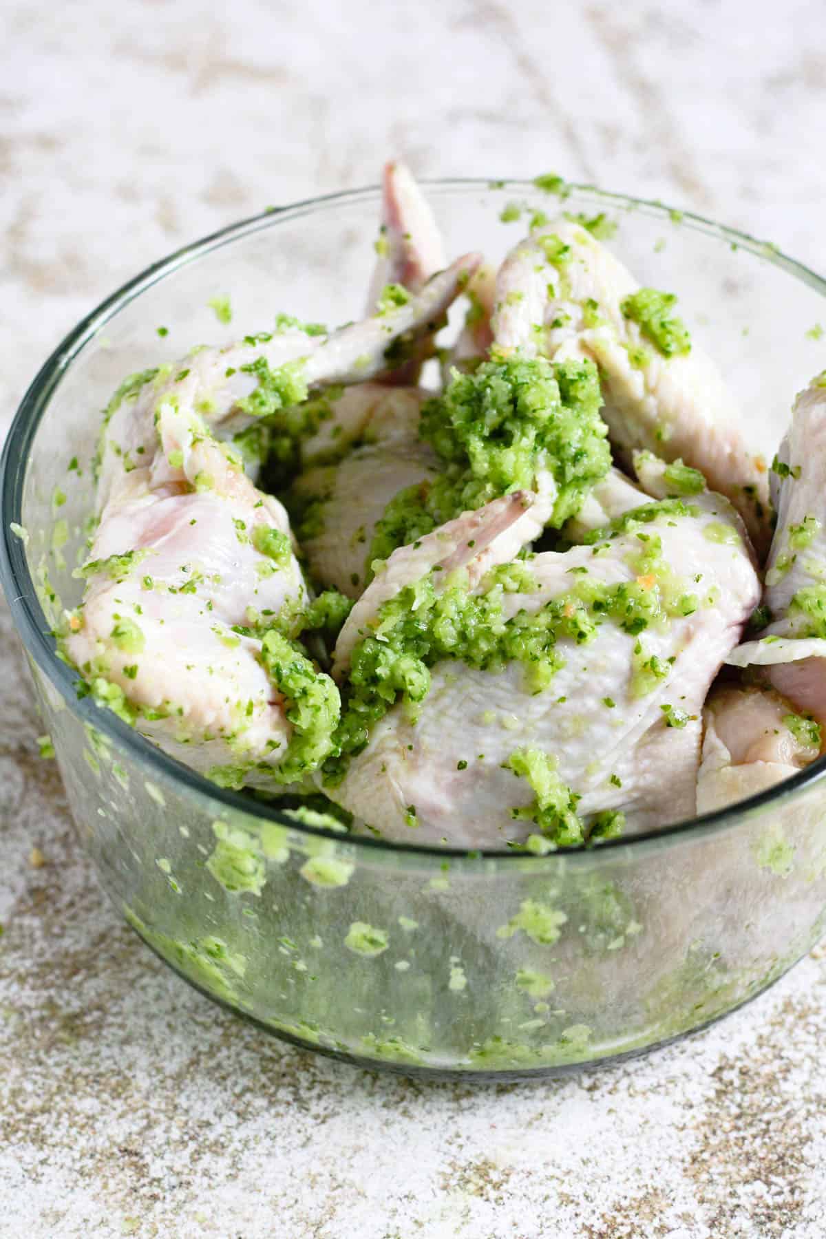 Chicken wings marinating in green sauce