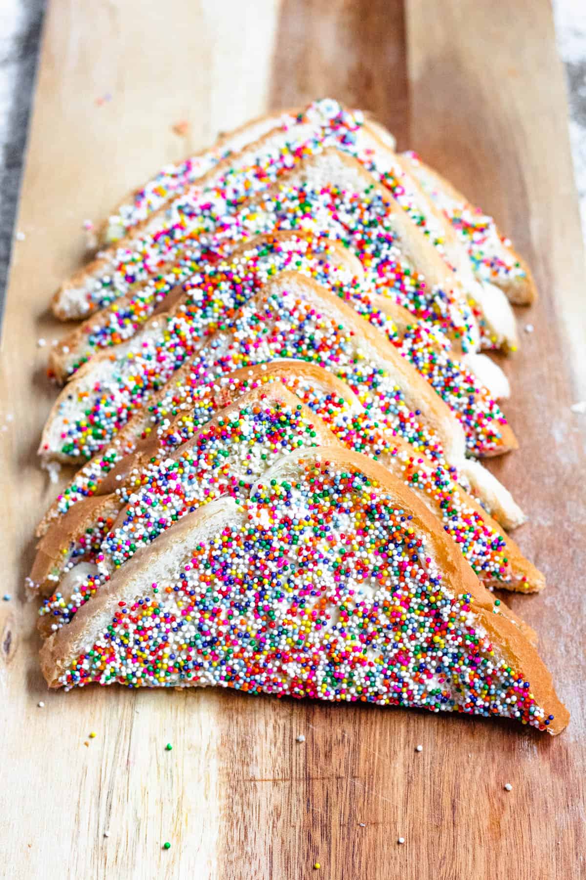 Pieces of Fairy Bread lined up on a board