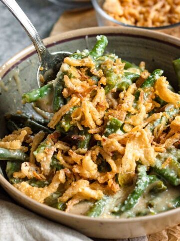 Instant Pot green bean casserole in a bowl topped with crispy onions.