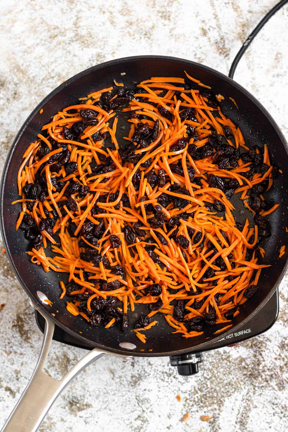 Cooked carrots and raisins in a pan 
