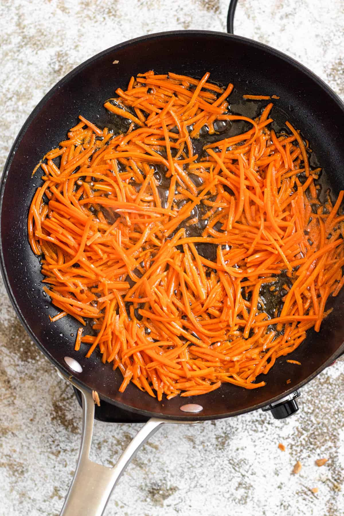 Sauteed matchstick carrots in a pan 