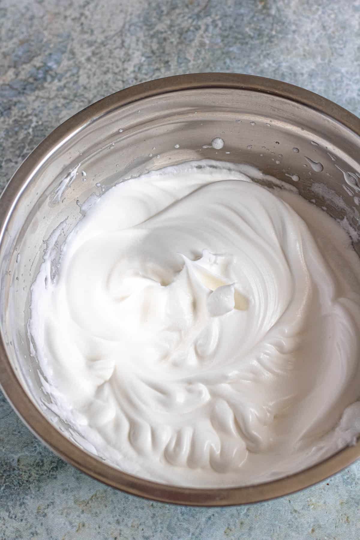 Whipped stiff egg whites in a mixing bowl 
