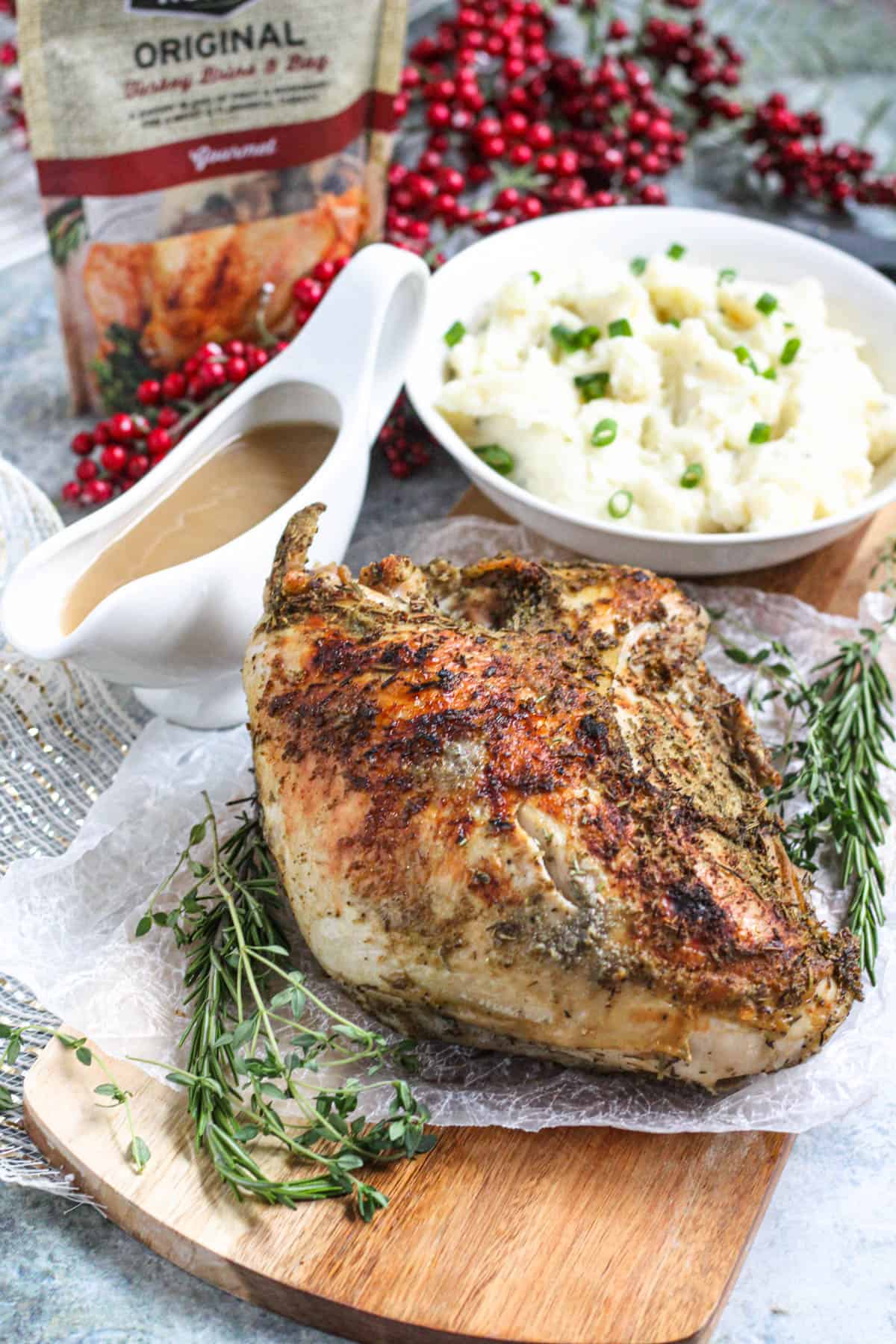 Full, roasted turkey breast surrounded by herbs