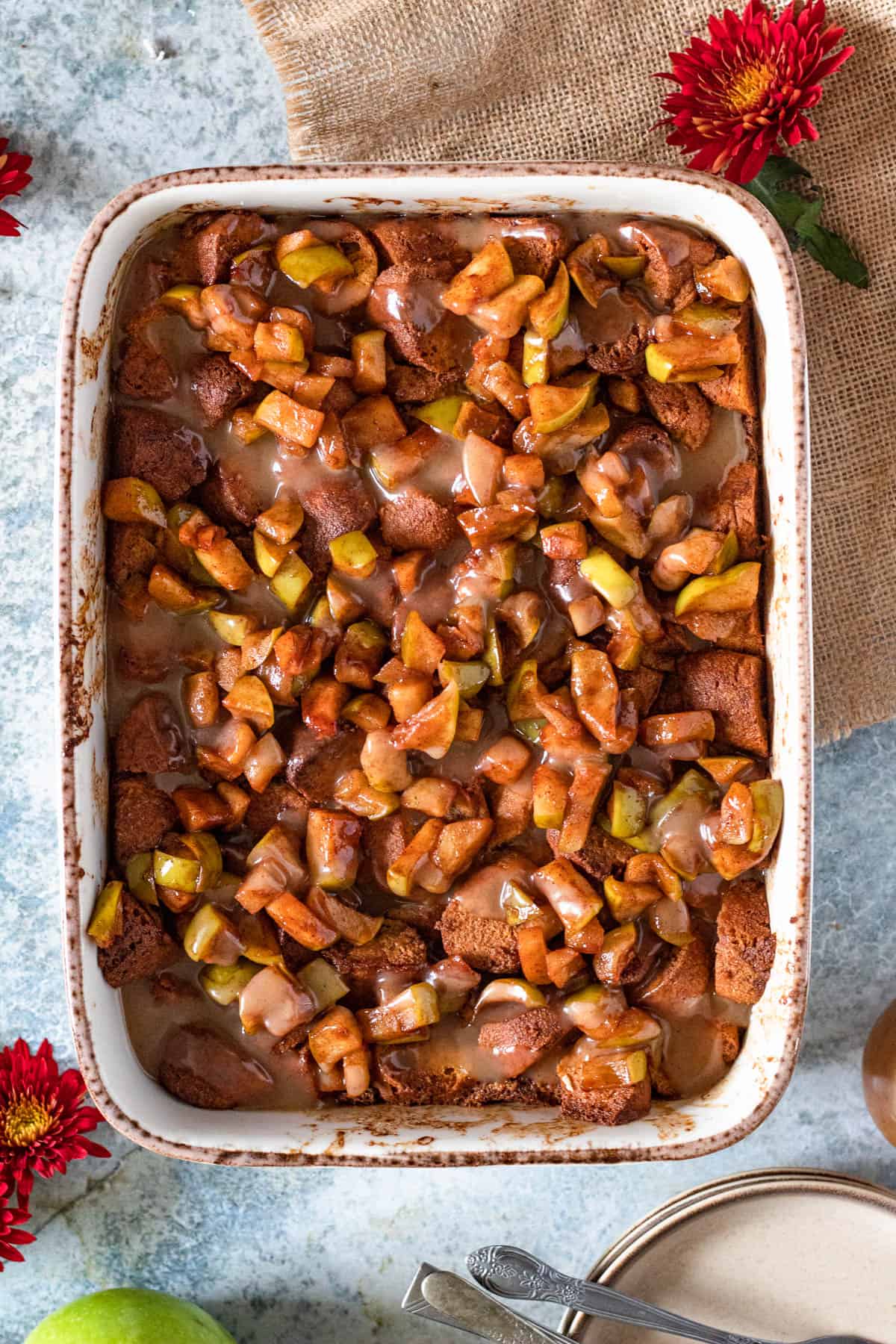 Baked apple cider donut bread pudding with apples and vanilla sauce