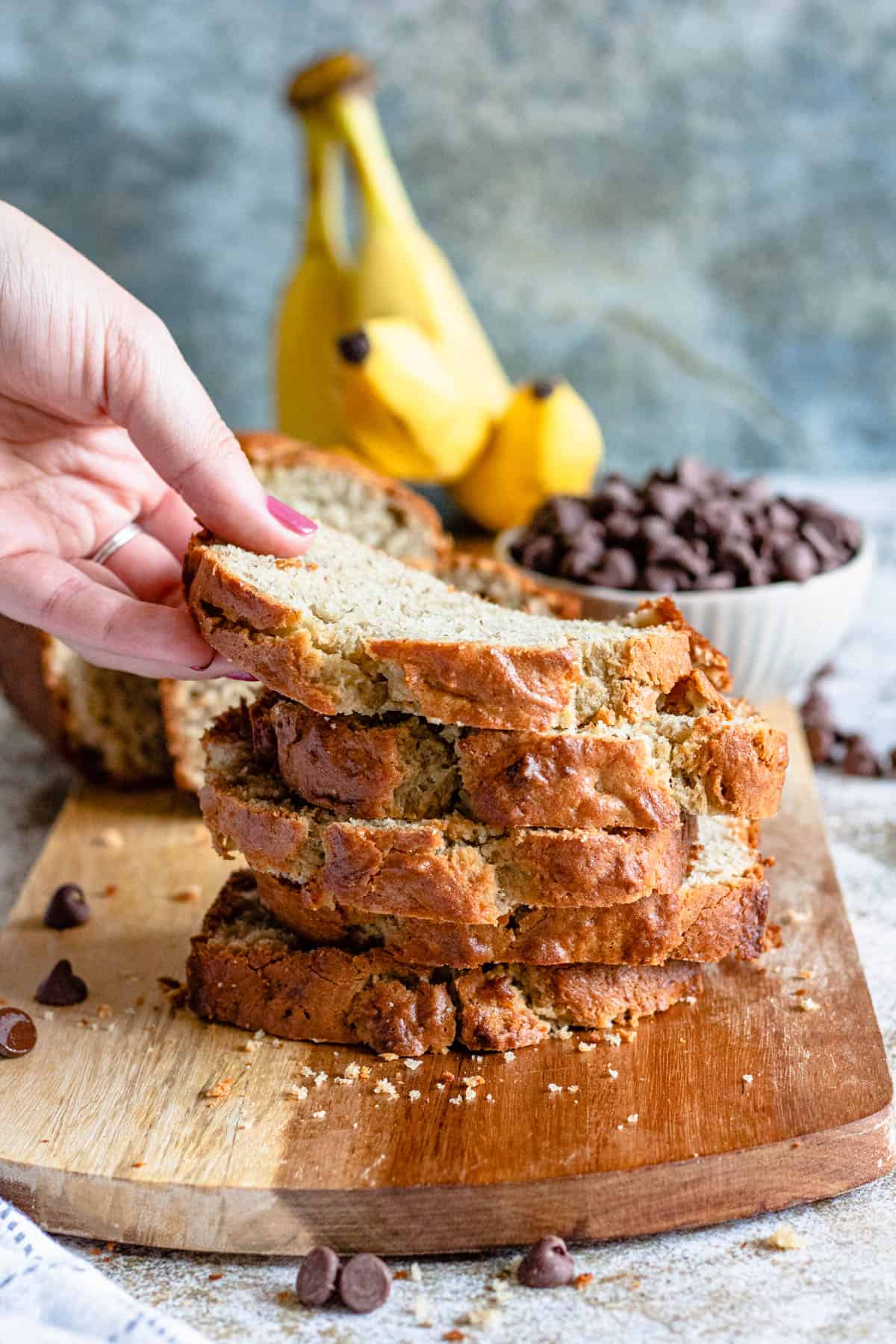Pile of banana bread slices with a hand grabbing a piece