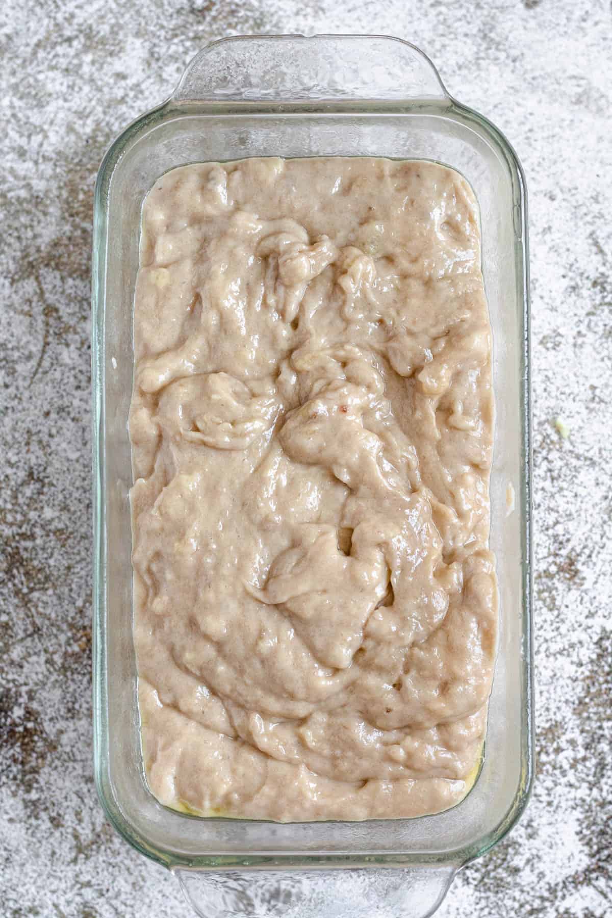 Banana bread batter in a glass loaf pan 