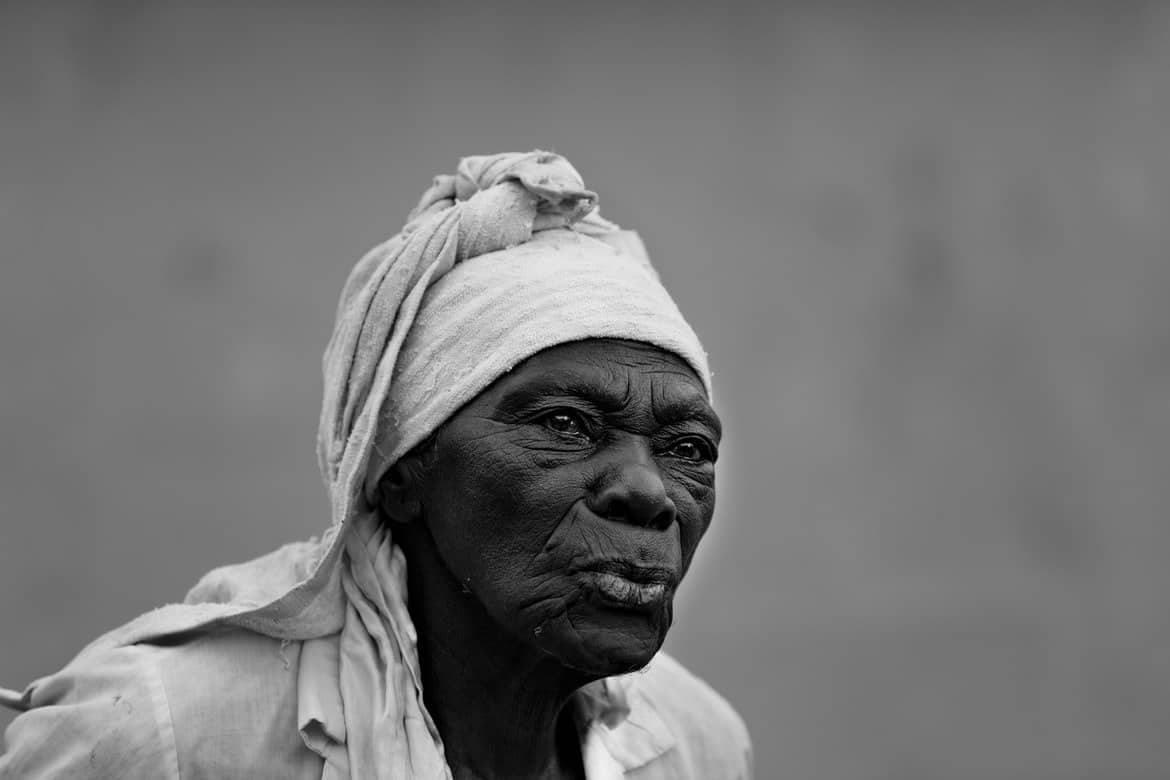 Black and white photo of a Haitian woman with a head wrap and pursed lips