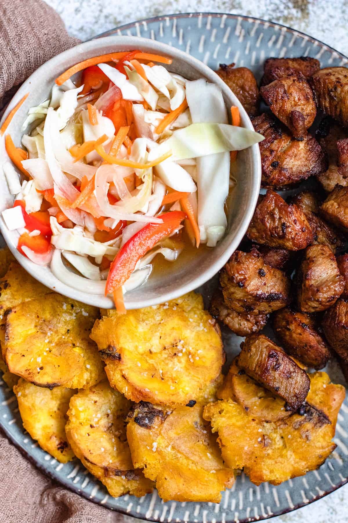 close up of griot, plantains, and pikliz 