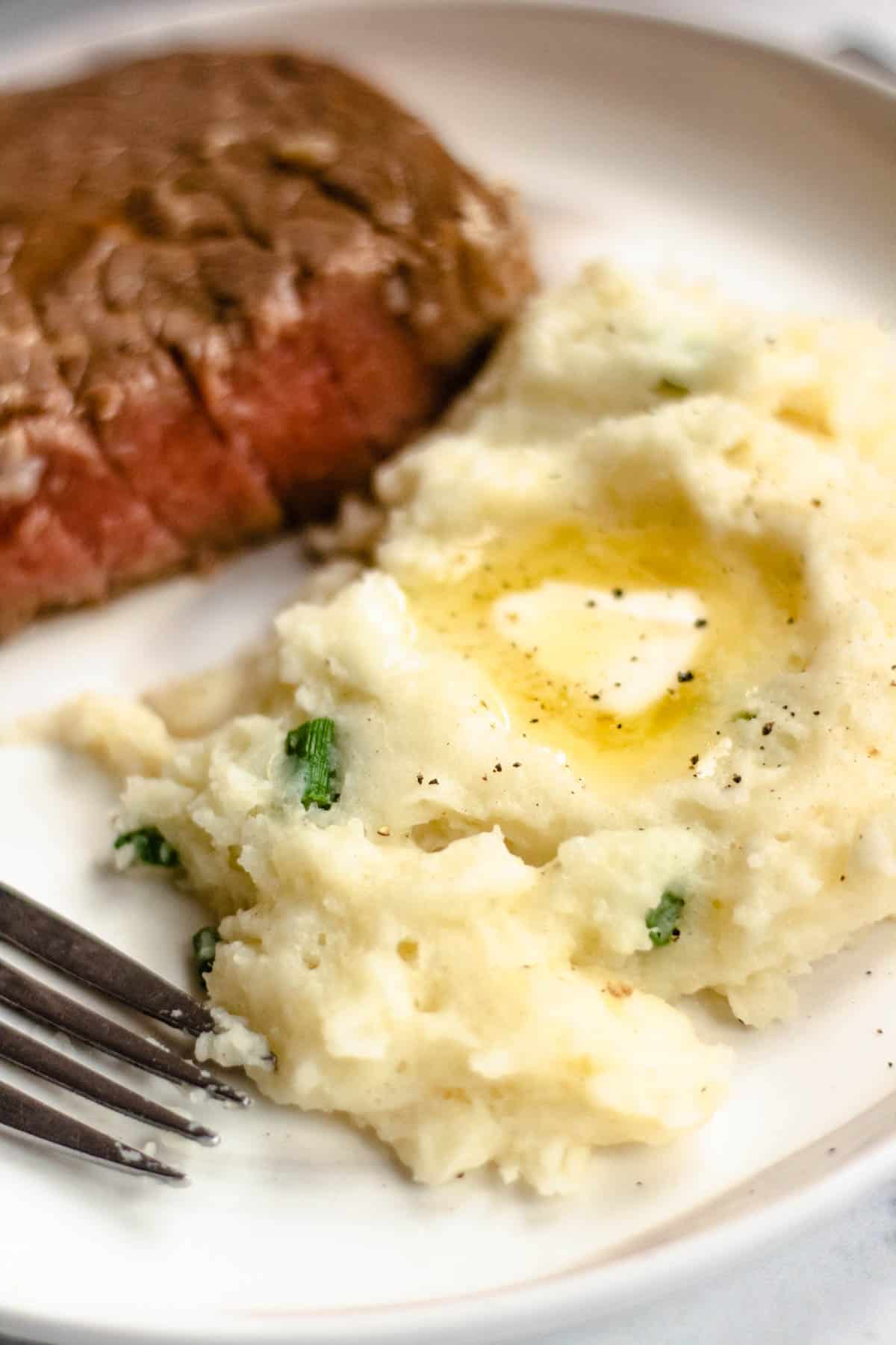 pile of horseradish mashed potatoes with melted butter on a plate
