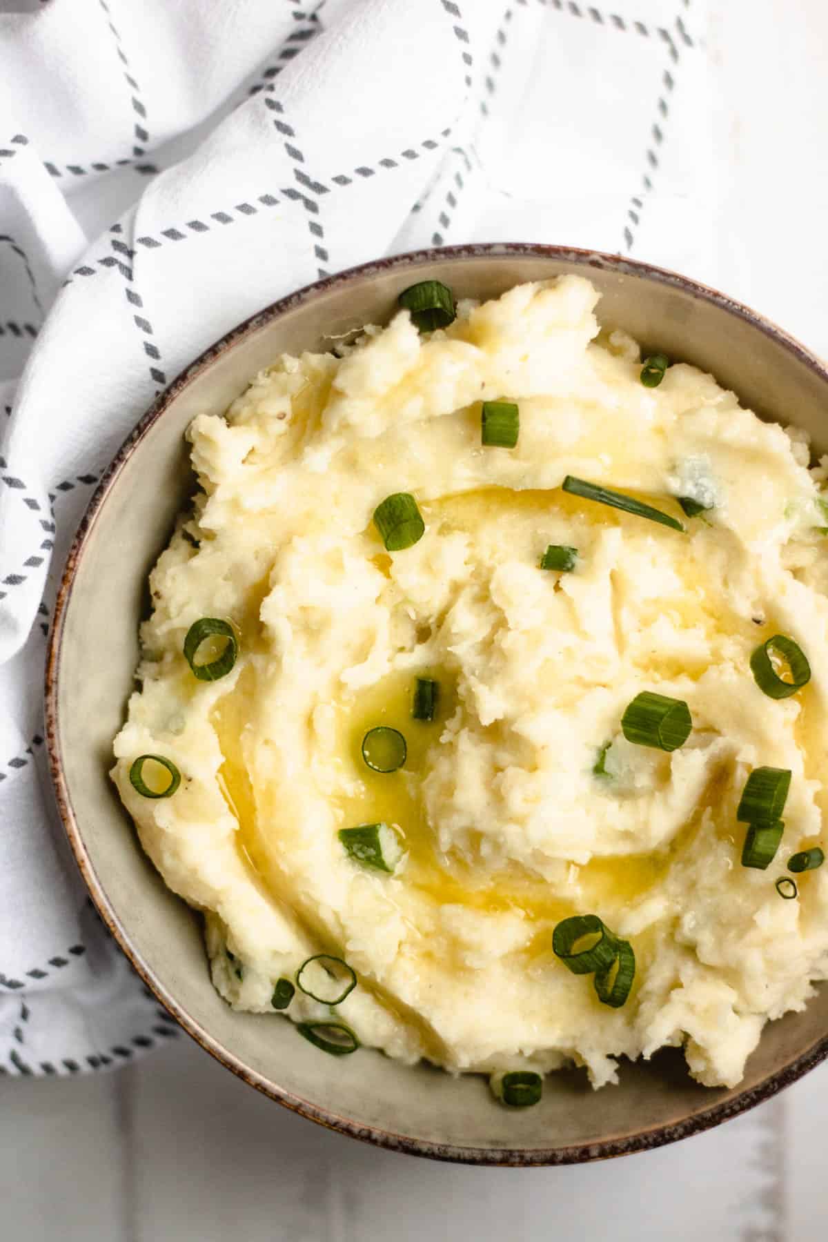 Bowl of Horseradish mashed potatoes with a napkin and green onions