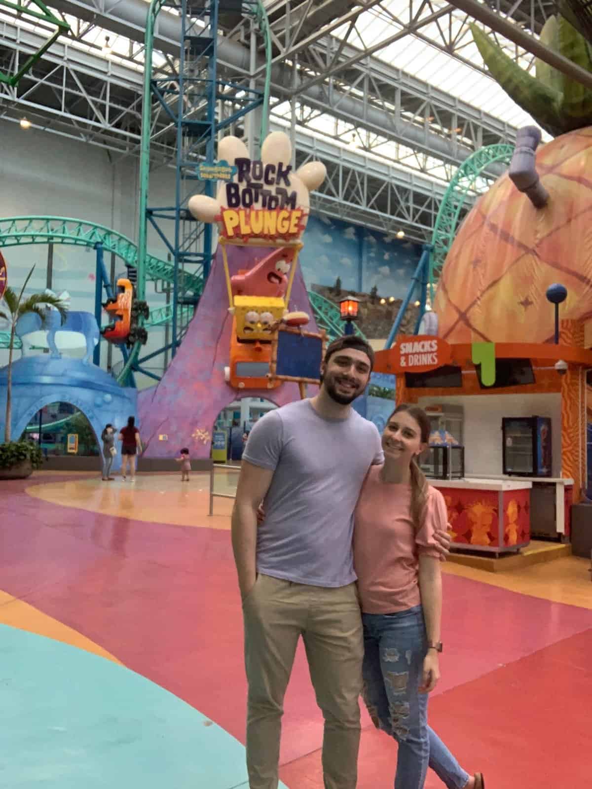 A man and woman posing at the amusement park in the Mall of America.
