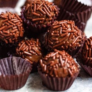 Close up of chocolate brigadeiro with chocolate sprinkles in a little paper cups.
