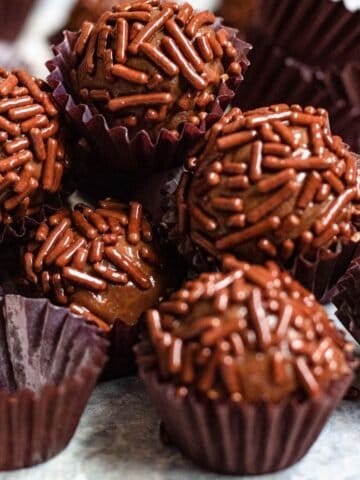 Close up of chocolate brigadeiro with chocolate sprinkles in a little paper cups.