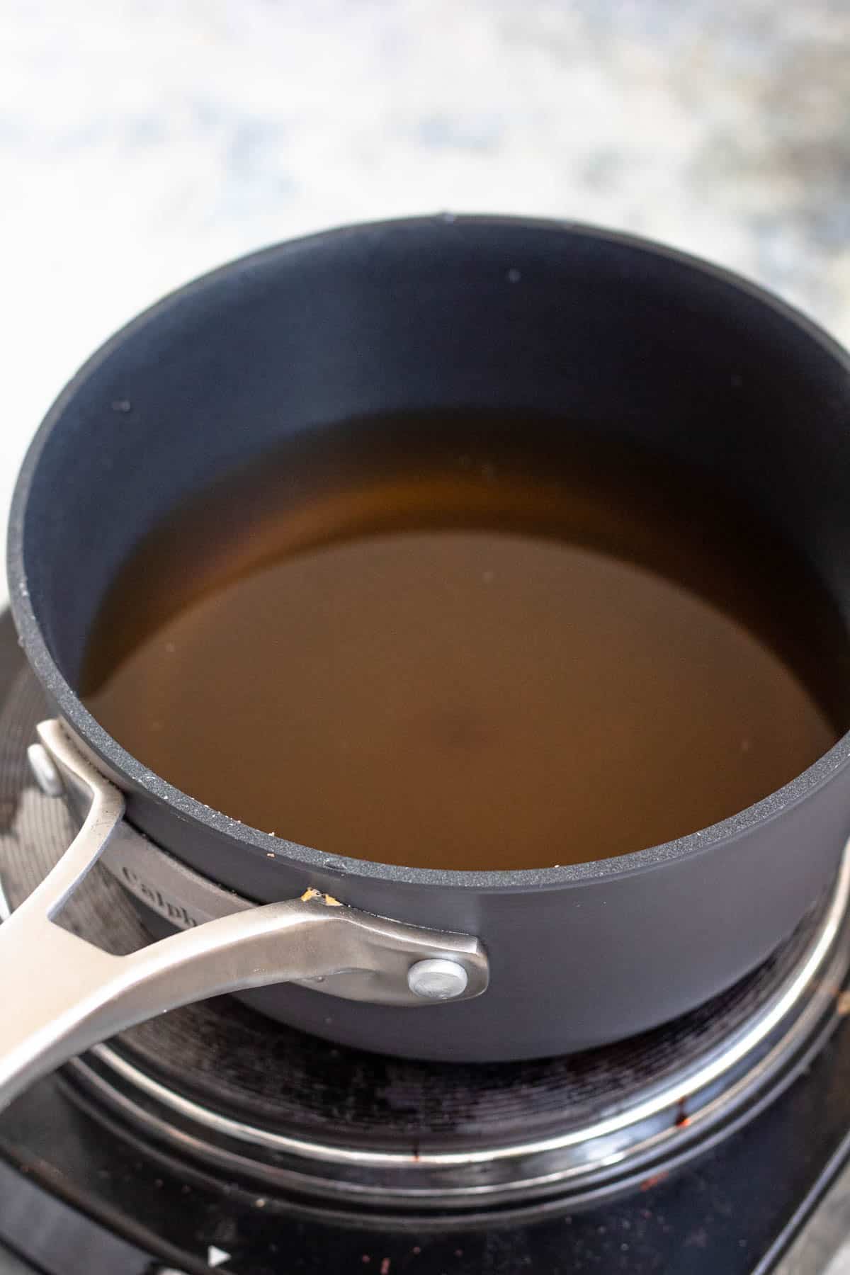 Cinnamon tea in a small pot on the stove 