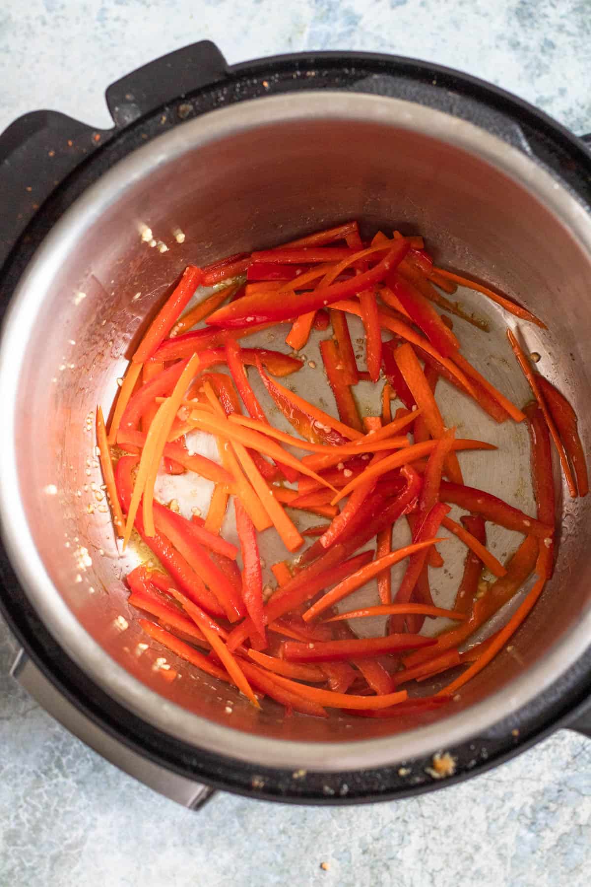 Garlic, carrots and peppers sauteing inside the Instant pot. 