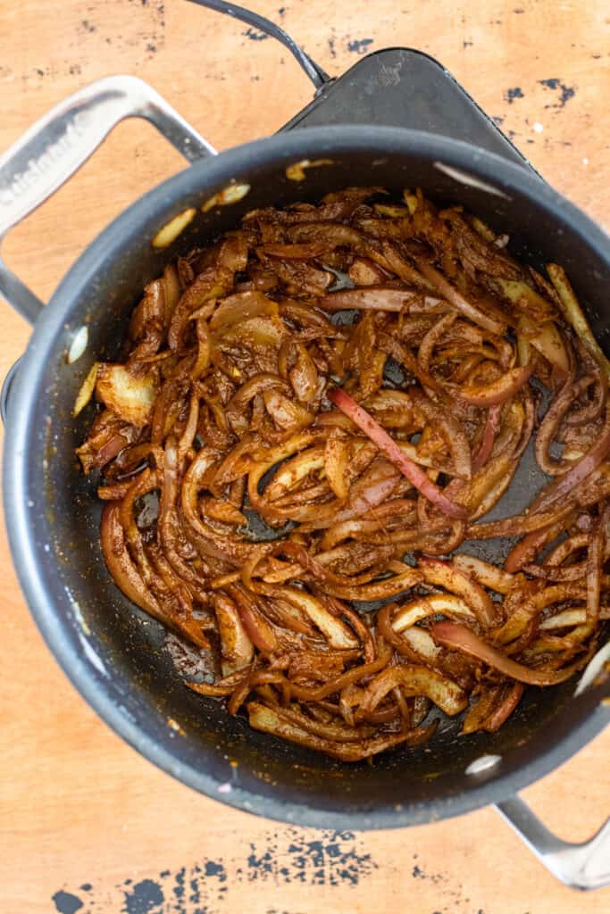 Seasoned and sauted red onions in a pan. 