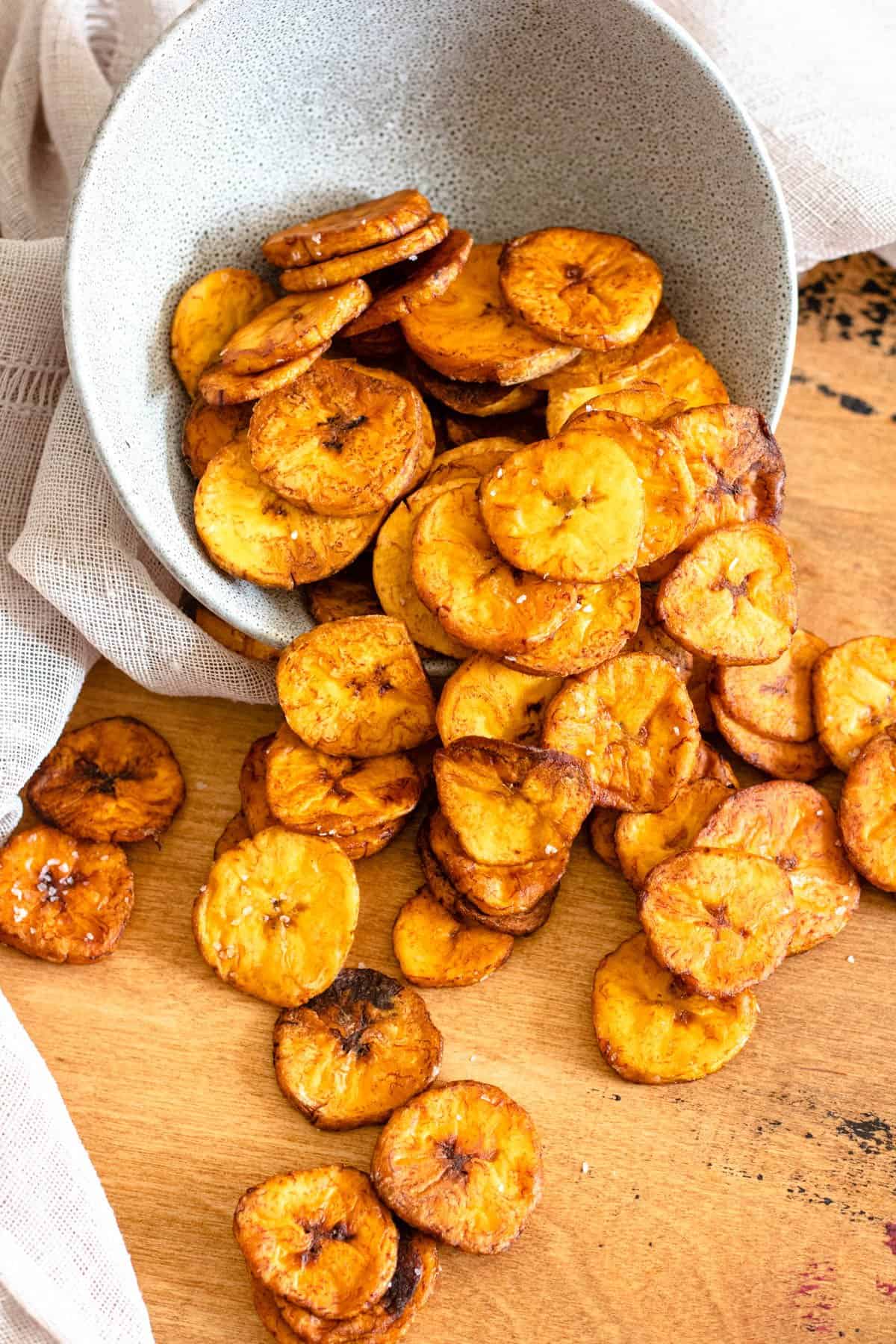 Bowl of sweet plantain chips spilling out onto the counter. 