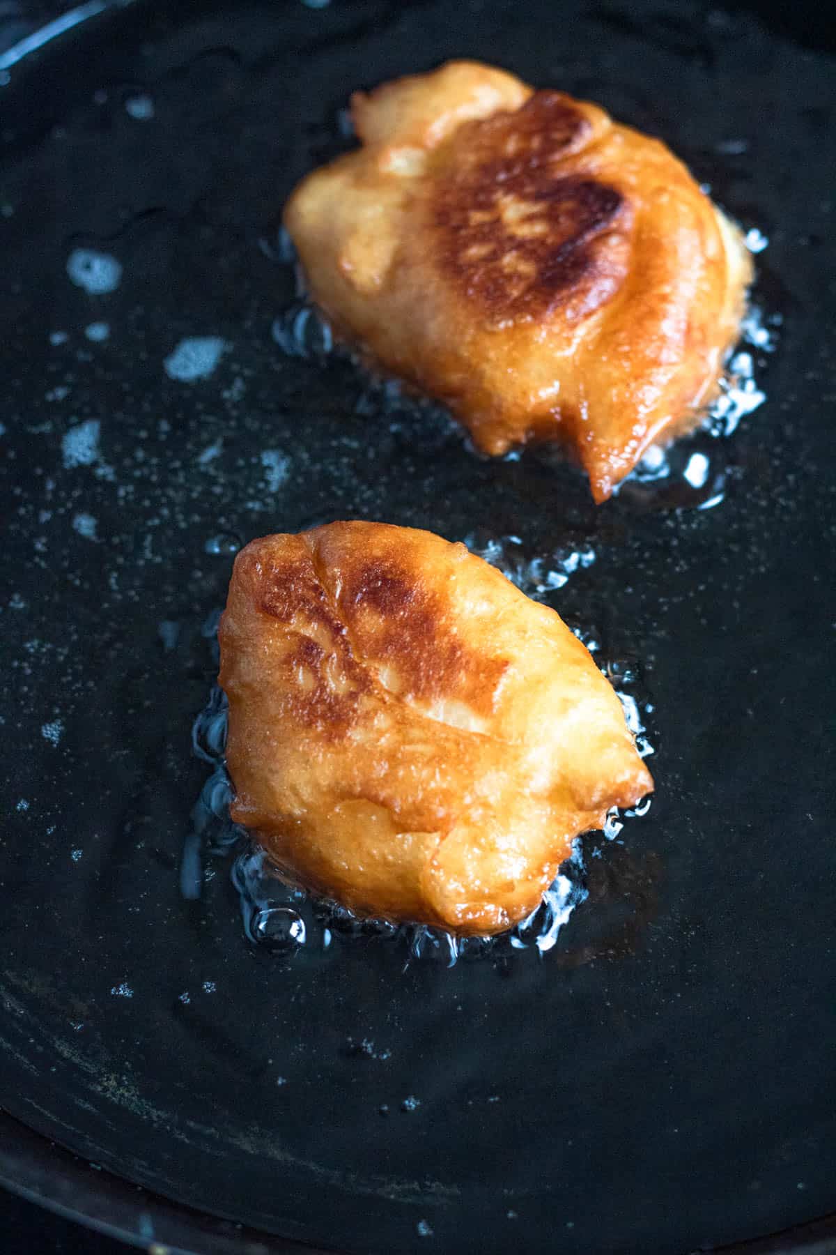 Frying up loukoumades in oil. 