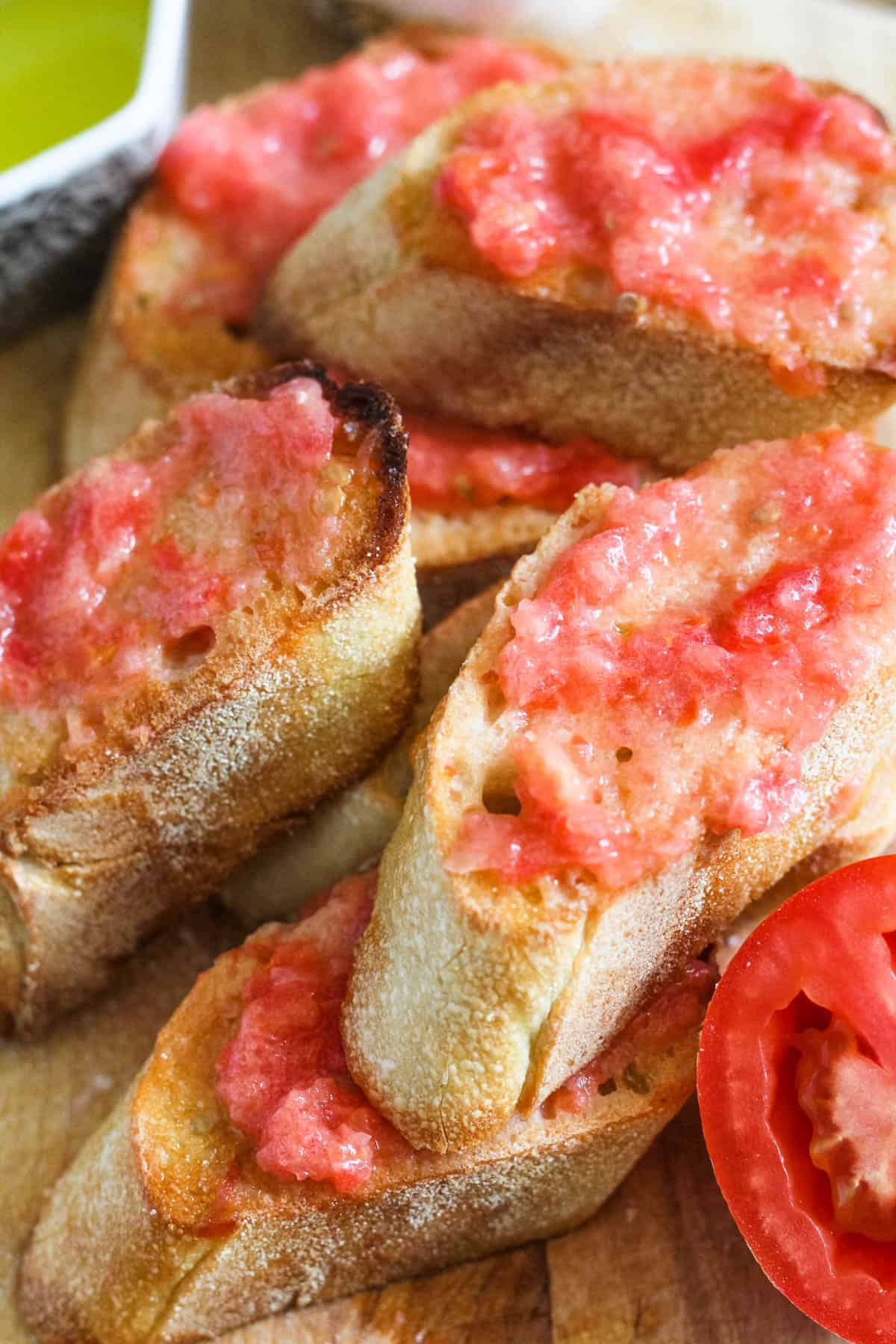Close up view of several pieces of pan con tomate. 