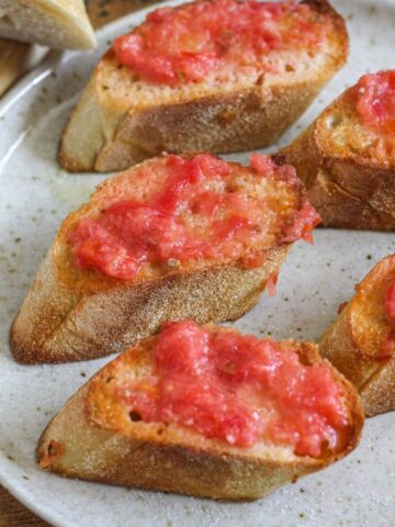 Slices of pan de tomate on a serving plate.
