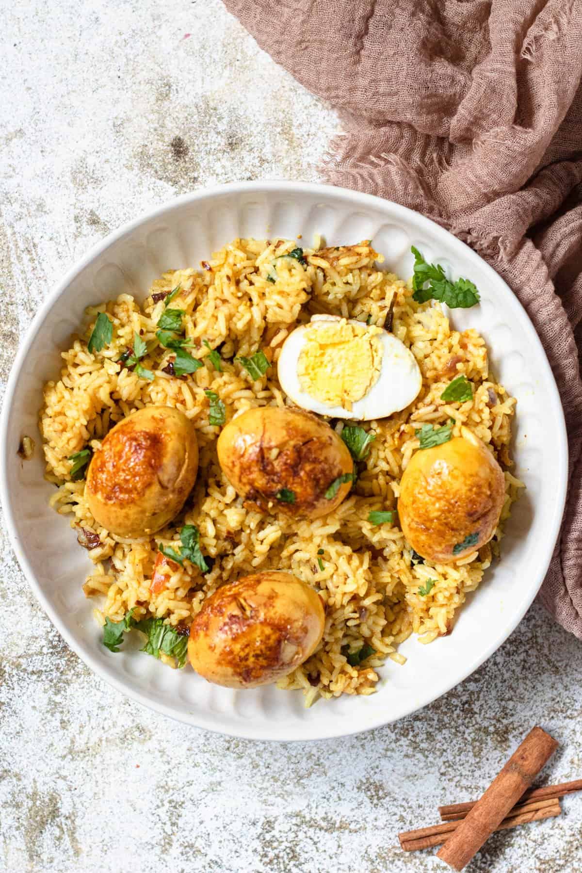 Egg Biryani with rice and hard boiled eggs, topped with mint and cilantro 