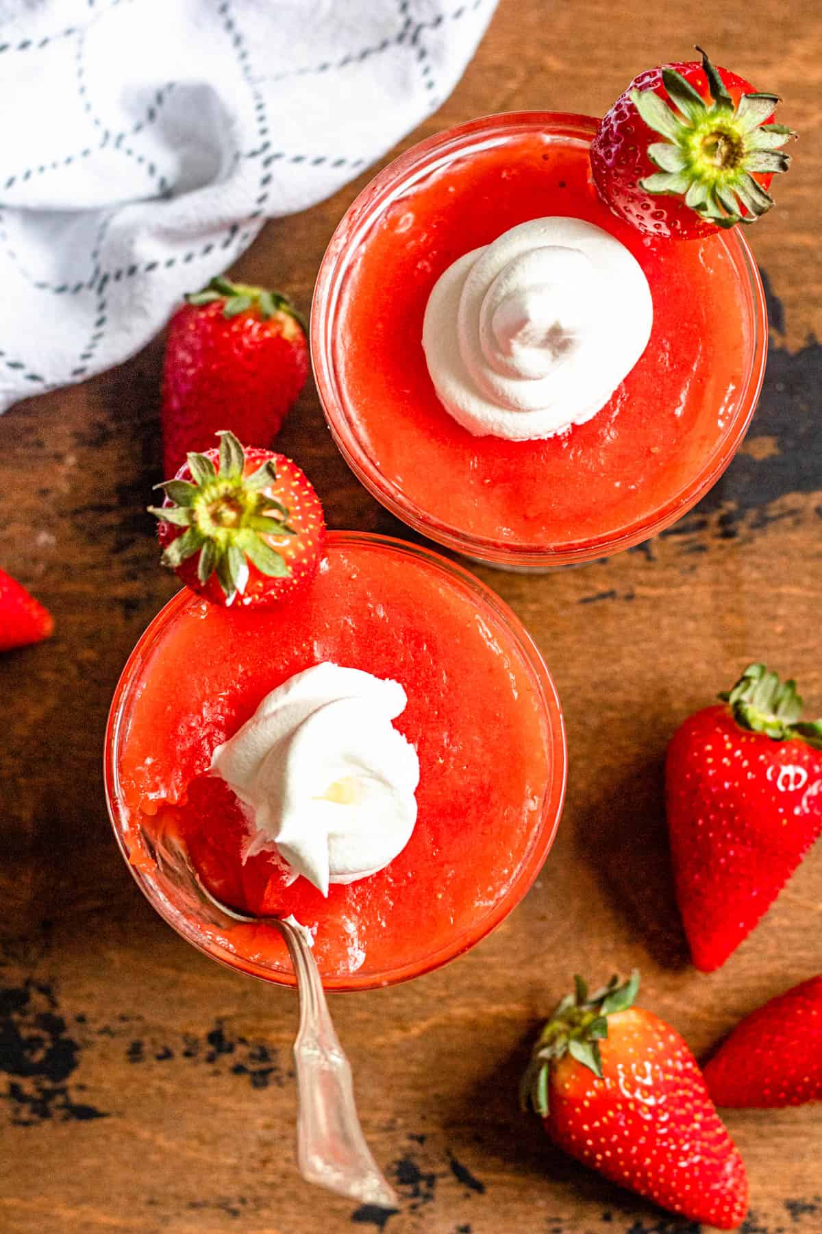 Top view of strawberry kissel in serving glasses with whipped cream on top. 