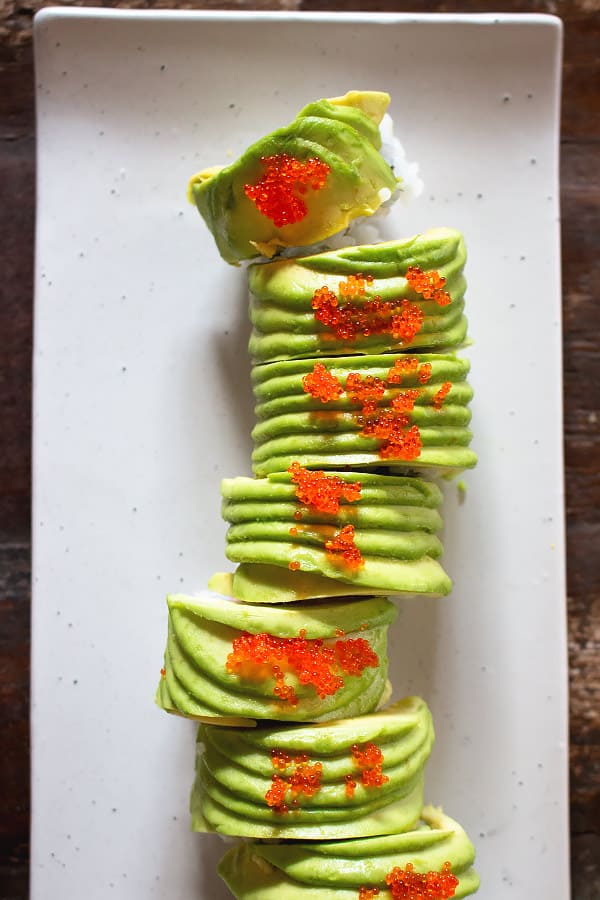 Dragon roll slices on a white serving platter. 
