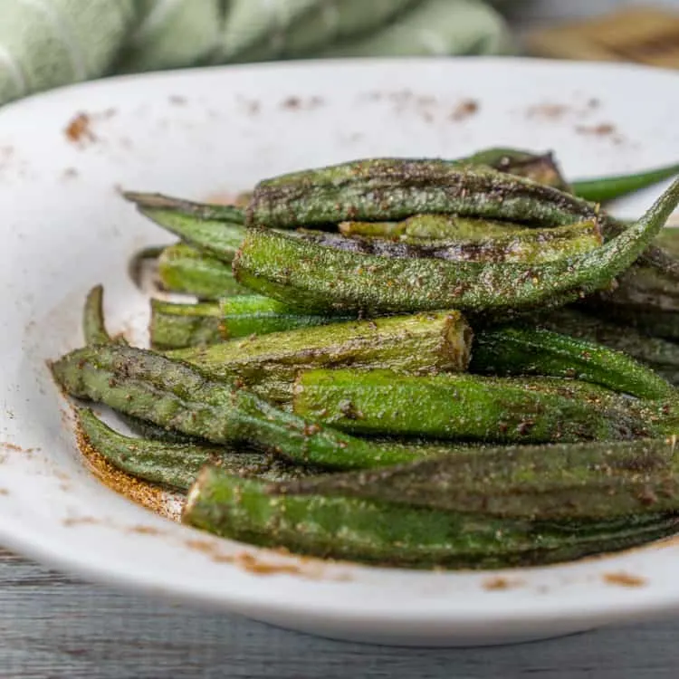 Roasted cajun okra in a small white serving bowl. 