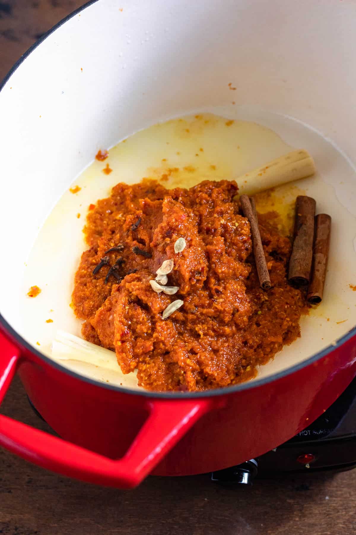 A dutch oven with the spice paste added as well as other seasonings. 