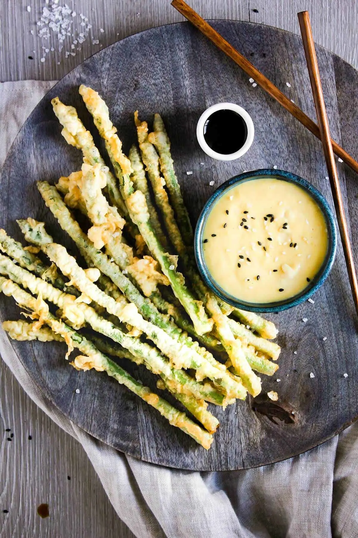 Asparagus tempura on a plate with.a small dipping sauce of miso aioli alongside. | Tao of Spice