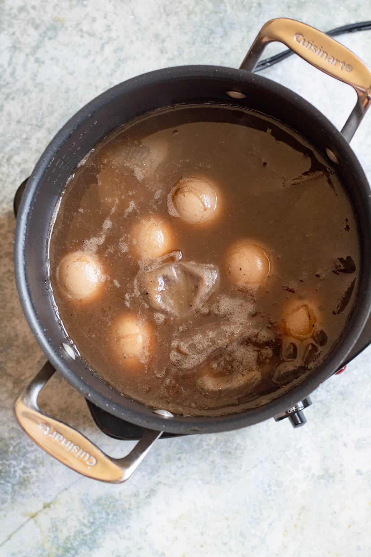 A pot with water, onion skins, and brown water to dye the eggs brown. 