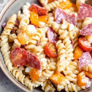 Instant Pot Pasta Salad with rotini noodles, feta cheese, cherry tomatoes, salami, and bell peppers.