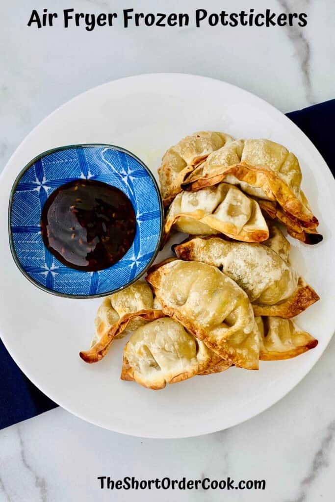 Air fryer pot stickers served on a plate with a small bowl of dipping sauce. 