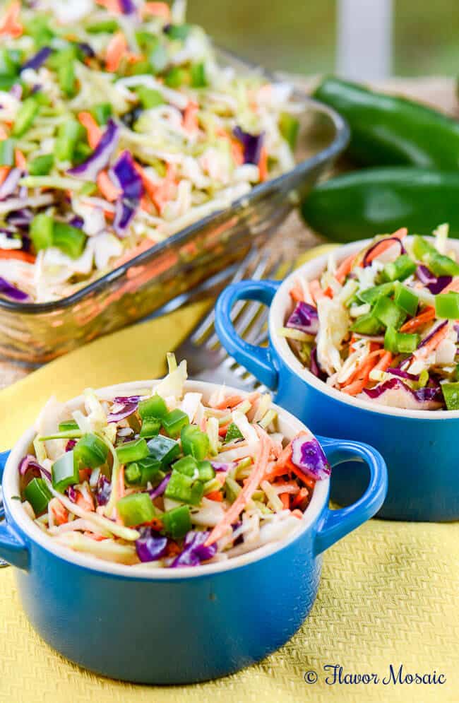 Cajun honey jalapeno slaw sitting behind two small bowls of it ready to eat. 