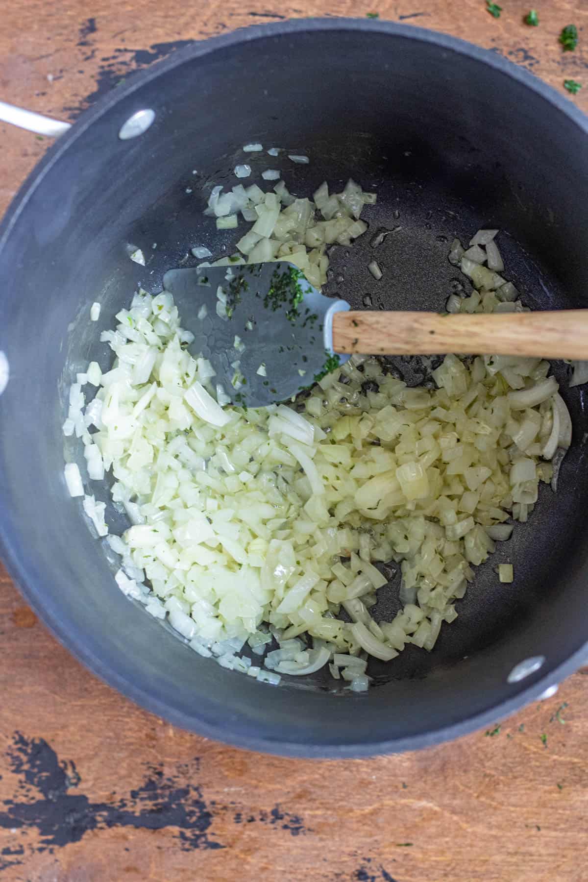 Diced onions sauteing in a pan. 