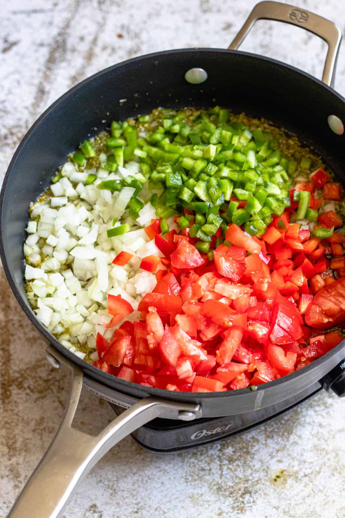Chopped vegetables added to a frying pan. 
