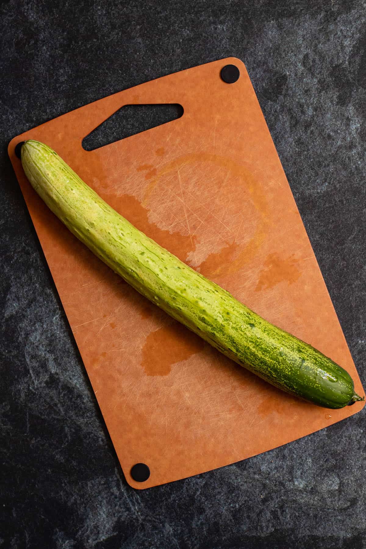 Korean cucumber laying on top of a cutting board. 
