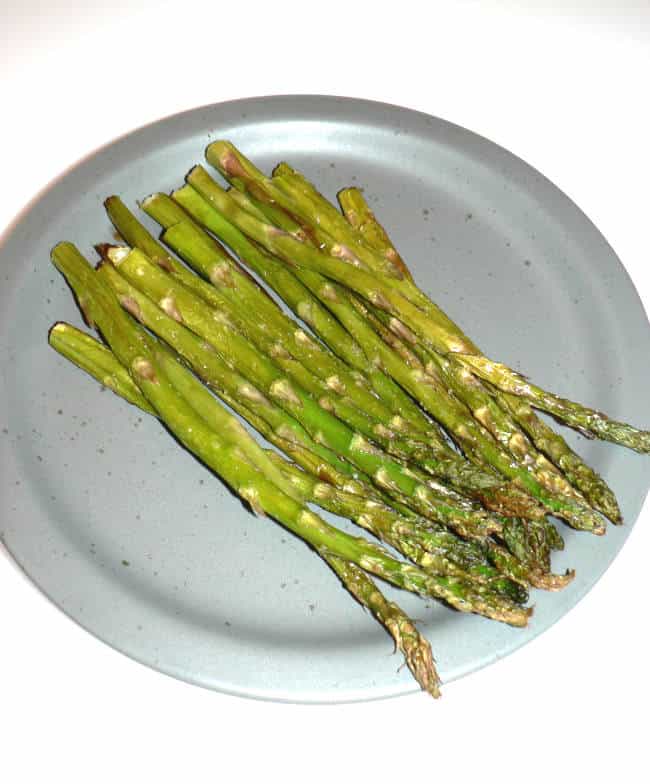 Air fryer asparagus on a blue plate.