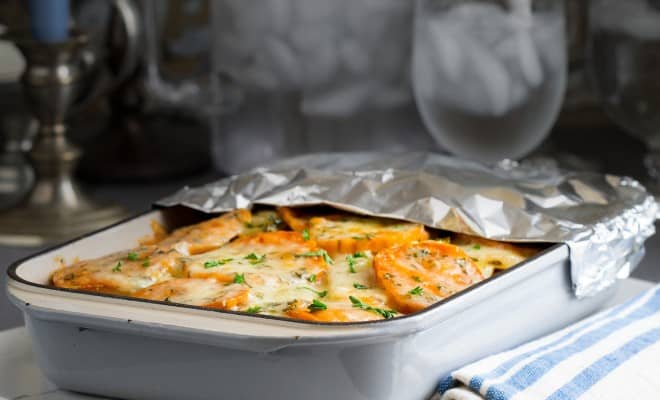 Baking dish with aluminum foil pulled back to reveal the baked meal. 