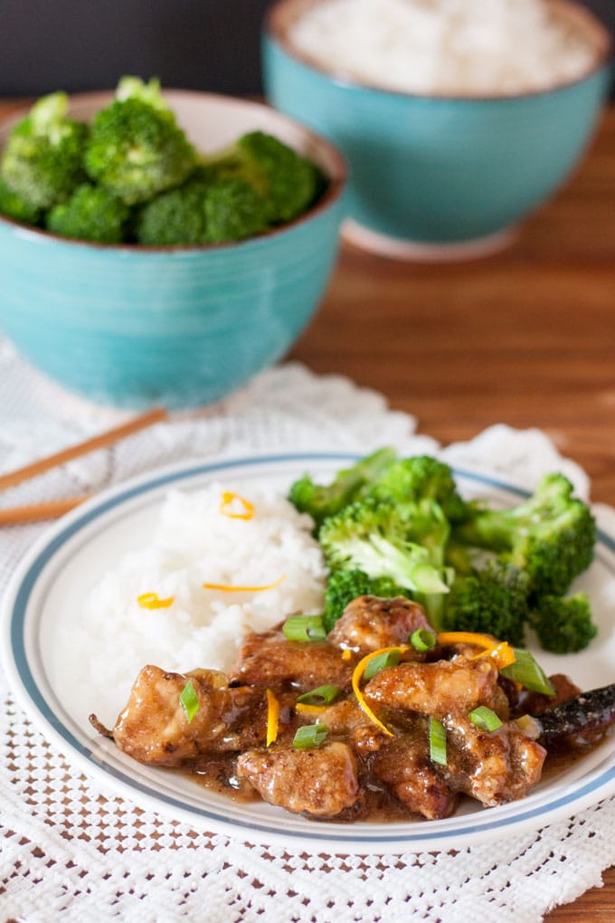 Seasame chicken served with  broccoli and white rice on a plate. 