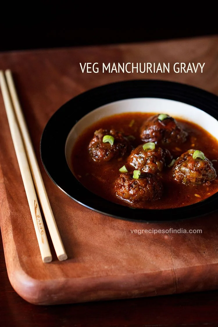Veg manchurian gravy in a bowl with chopsticks on the side. 